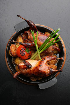 Whole Roasted Quail with Golden Potatoes and Grilled Tomato.
