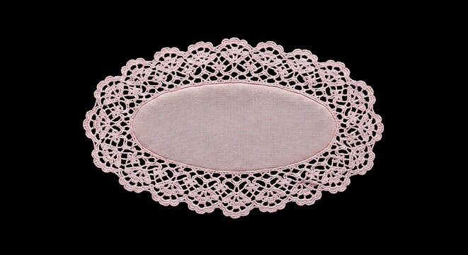 Close-up of a pink oval lace doily on a stark black background