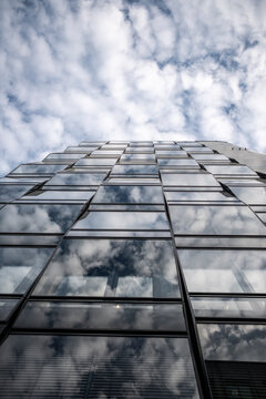 Upward perspective of modern skyscraper showing glass facade building windows and office architecture against sky for corporate business backdrop