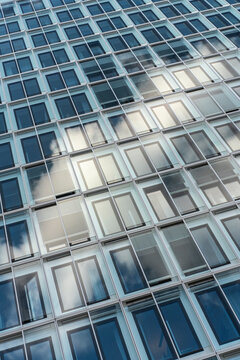 Abstract grid pattern on modern glass facade of office building windows showing architecture texture for corporate business background design