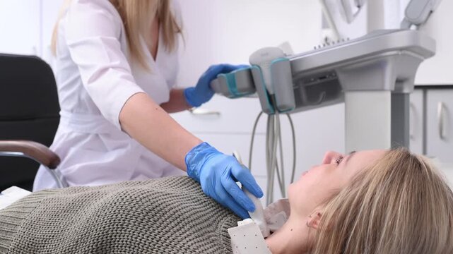 An endocrinologist examines a patient's thyroid gland using an ultrasound machine. Ultrasound machine