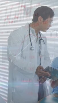 Vertical video: Doctor leaning to colleague tapping tablet and showing medical charts for review