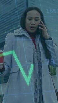 Vertical video: Commuter walking on phone, call causing market chart on cup tracking stocks