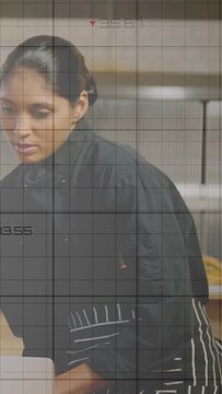 Chef reading and entering recipe data on laptop in kitchen, causing numeric grid overlay updating