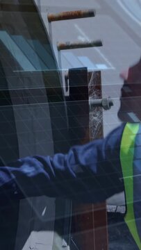 Vertical video: Construction tech using phone or tablet checking bolts showing overlay for alignment