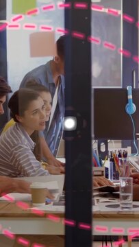 Vertical video: Man handing pages design team leaning inspecting comps pink ring framing for review