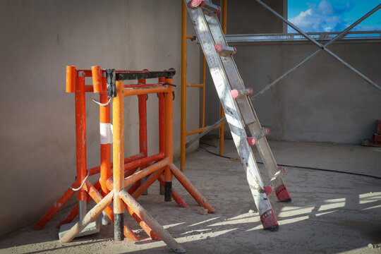 Construction site with scaffolding, ladder, and sawhorse, ready for building work