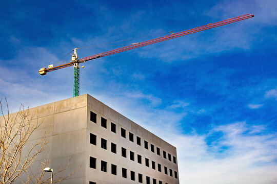 Escena de construcci&oacute;n urbana que simboliza el crecimiento, el progreso de la ingenier&iacute;a, el desarrollo industrial y la expansi&oacute;n de la ciudad moderna bajo un cielo despejado. Una gr&uacute;a torre 