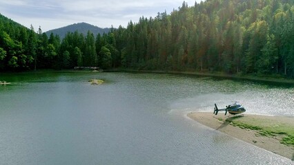 Helicopter fly up from island on lake © Vladislav