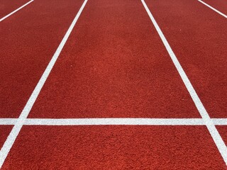 Fototapeta premium red running track with white lane lines background