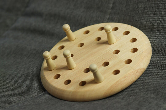 Wooden memory chess game puzzle board placed against a soft, textured fabric background.