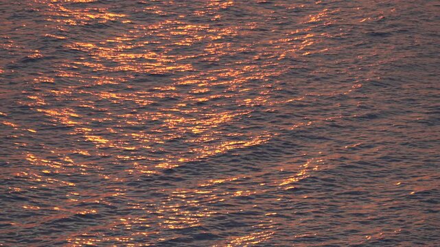 Ocean waves, golden light, water surface shimmering at sunset with beautiful reflections
