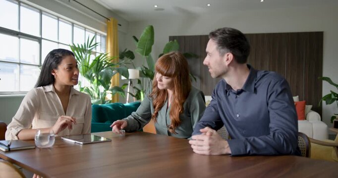 Financial advisor meeting with a couple to discuss finances, using Digital tablet