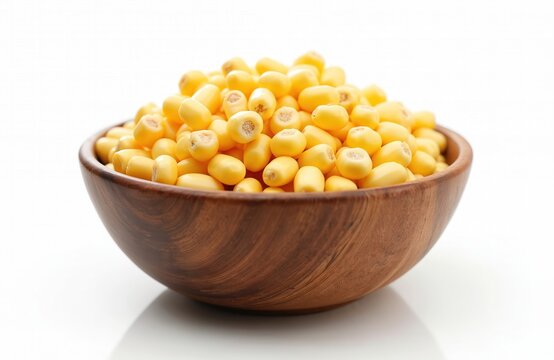 Baby corn kernels fill a natural wood bowl. These small, tender vegetables are isolated on a clean white background, perfect for healthy recipes.
