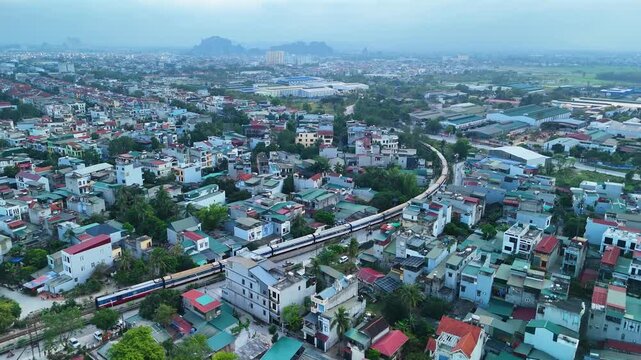 The train runs through a densely populated residential area in Vietnam