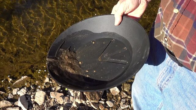 Creek silt is panned for gold.