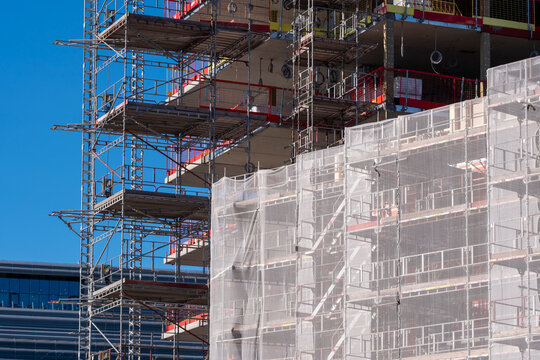 Oslo urban construction features steel scaffolding in grid with netting across a new building facade showing structure and modern development as it grows