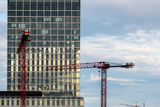 Berlin skyline shows crane and urban construction around glass office highrise tower during development with modern architecture and growth