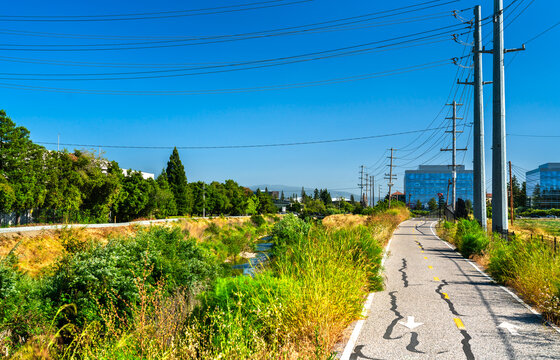 A scenic paved bicycle path follows the San Tomas Aquino Creek near corporate offices in Silicon Valley, Santa Clara, California