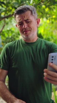 Man struggling to see smartphone screen outdoors