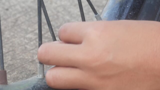 Hands opening and closing the valve of a bicycle tire