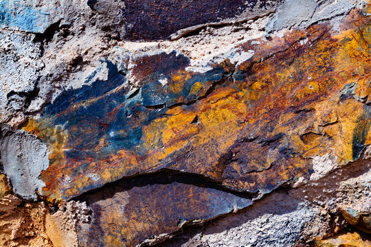Superficie rocosa mineral colorida que muestra patrones naturales, procesos geol&oacute;gicos, efectos de oxidaci&oacute;n y una vibrante textura org&aacute;nica. Primer plano de una superficie rocosa multicolor con capas