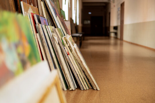 Many paintings in the gallery hallway. The art school is preparing an exhibition. 