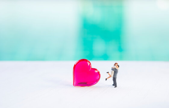 Miniature couple with red heart with space on blurred background, love and romance, valentine background idea