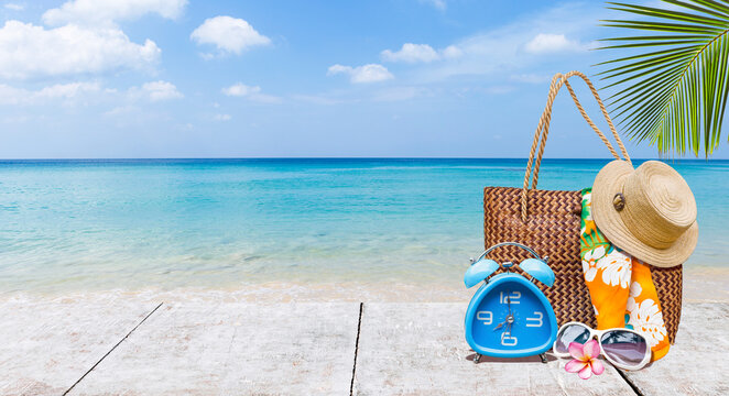 Summer items on wooden table over tropical beach, it's summer time, holiday and vacation destination, travel industry