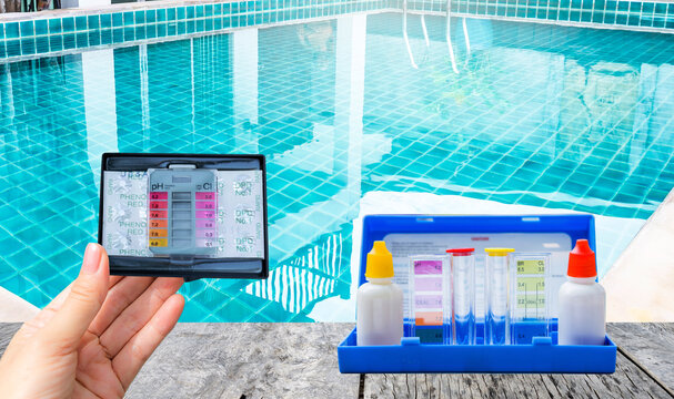 Water tester test kit in girl hand over blurred swimming pool water background, quality water testing test kit, pool maintenance and service business concept