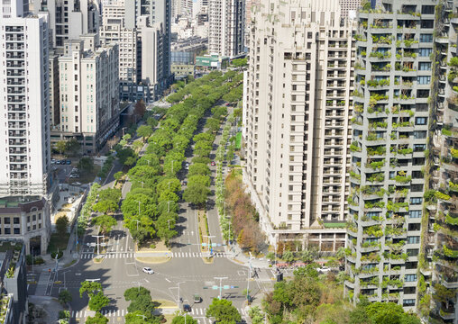 Aerial view of modern residential skyscrapers and a lush tree-lined boulevard with vertical greenery on building facades in Hsinchu, Hsinchu City, Taiwan.