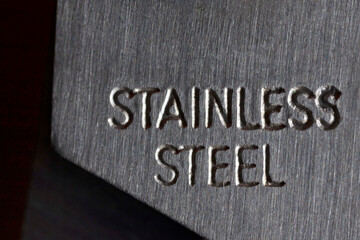 Fototapeta premium Stainless steel text engraved on brushed metal surface