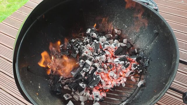 Barbecue charcoal burning to light the fire ready for cooking