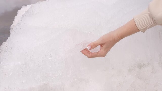 Cold therapy concept hand touching ice surface cold sensation awakens skin cold exposure boosts circulation and energy macro shot of frozen texture sensory experience wellness and recovery ritual
