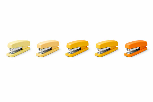 Yellow to orange gradient staplers aligned in warm tonal transition creating energetic minimal composition for office stationery visuals