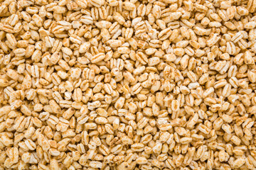 Fototapeta premium Yellow dry puffed wheat flakes background. Closeup. Top down view.