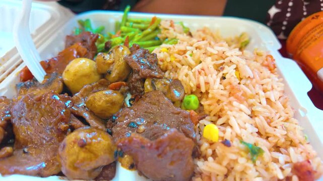 Chinese takeout container with beef mushroom stir fry and fried rice