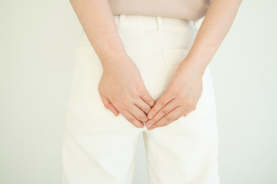 Woman suffering from anal pain and discomfort. Cause of pain include hemorrhoid, anal fissure, diarrhea, constipation or Crohn's disease. Gastrointestinal system concept.