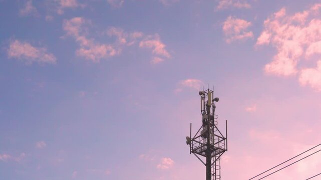 Cell Station, Cellular Tower, Cellular Equipment of Mobile Operator Time Lapse and White Pink Clouds in the Clear Colorful Sunset  Sky.