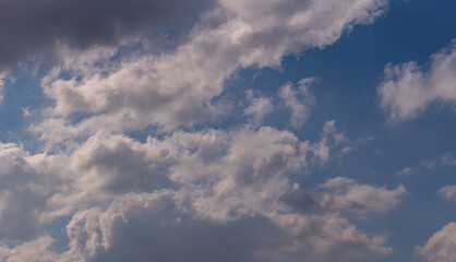 Obraz premium Dramatic Cumulus Cloudscape with Bright Sunlight and Blue Sky for Weather Forecasts and Atmospheric Backgrounds