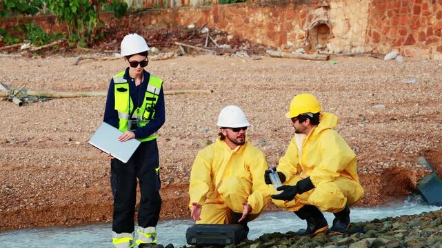 Female workers lead team male officers to inspect water pollution collecting samples of treated water discharged from a refinery test for toxic contaminants that may be present causing pollution and e
