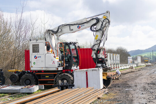 Onville, France - March 15th 2026 : View on a white road-rail wheeled excavator D2R ZX170-7 PRR on a construction site for the renovation of a railway line.	