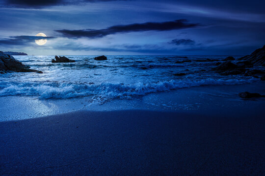 mysterious sandy sea beach at night. full moon over scene on cold summer vacation season. beautiful view of waves washing the sand. generic image of seascape and sky for advertising background