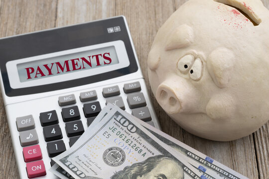 Worried piggy bank with payments and calculator