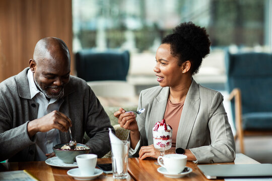 Business colleagues enjoying dessert at cafe