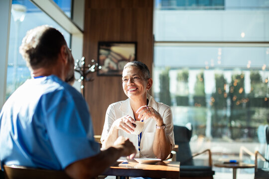 Healthcare coworkers chatting over coffee in hospital cafeteria