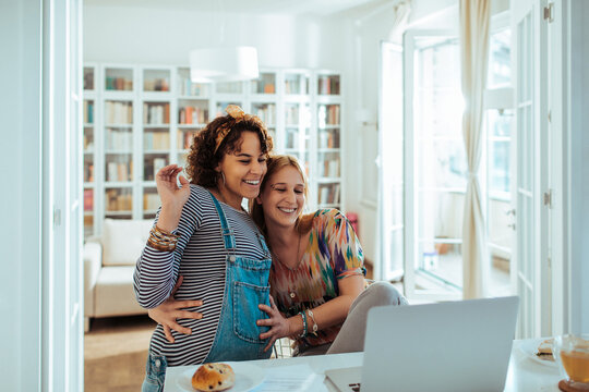 Expecting couple waving on video call at home