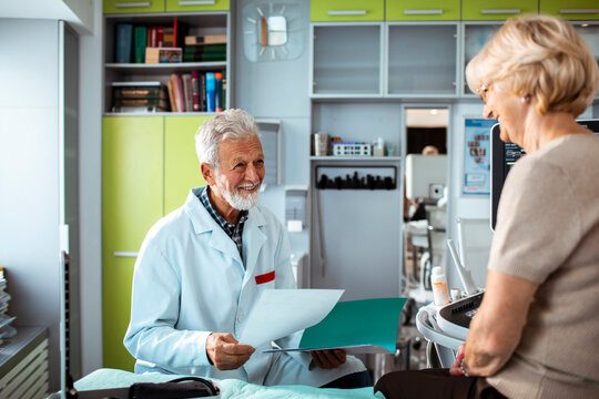 Senior doctor discussing test results with elderly patient in clinic