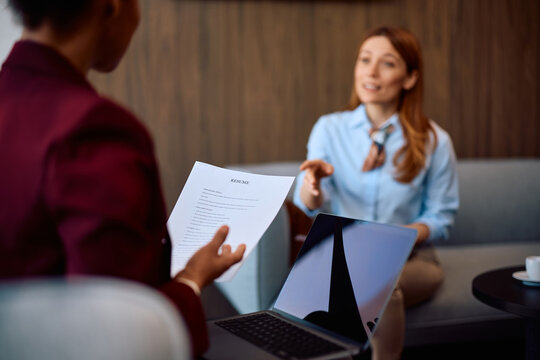 Close up of talent acquisition manager reading job candidate's CV in office.