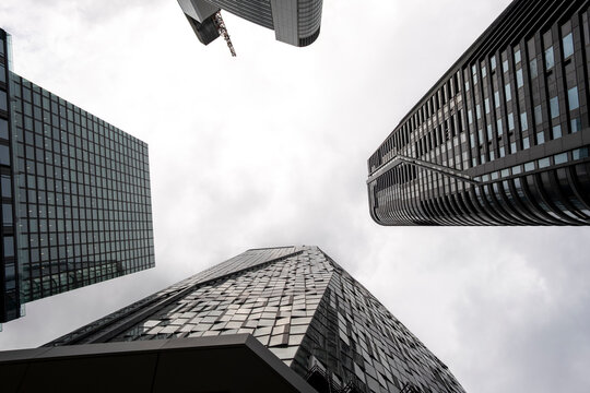 Upward perspective in Frankfurt shows modern glass skyscraper architecture with strong lines in an urban scene rendered in striking monochrome tones